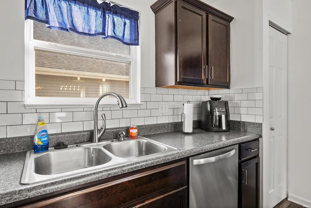 kitchen featuring dishwasher, dark countertops, a sink, dark brown cabinets, and backsplash