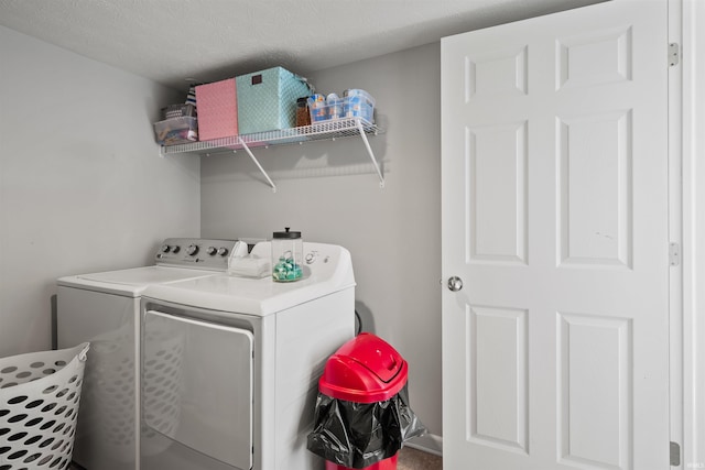 laundry room with laundry area, independent washer and dryer, and a textured ceiling