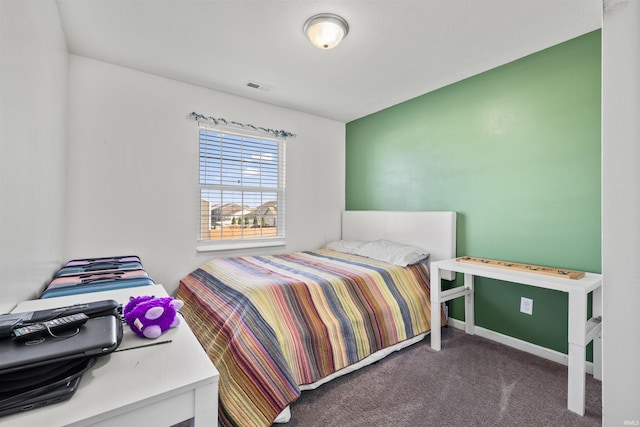 bedroom with baseboards, visible vents, and dark carpet