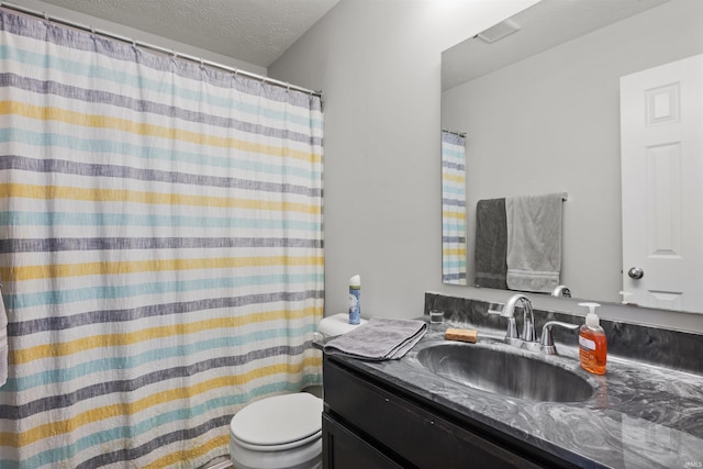 full bath featuring a textured ceiling, vanity, and toilet