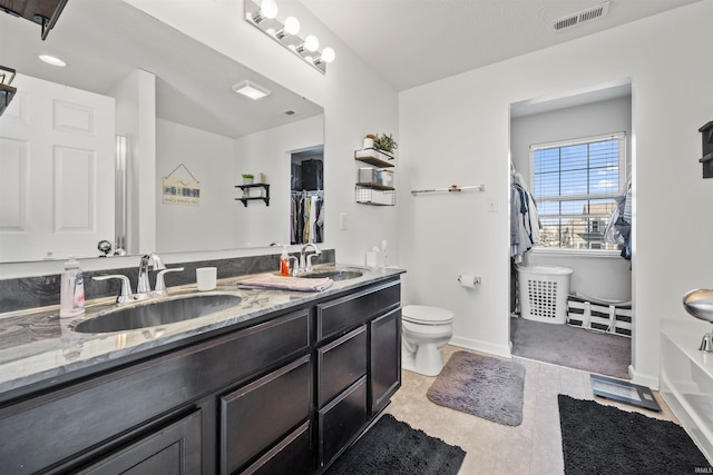 full bathroom featuring visible vents, a sink, toilet, and double vanity