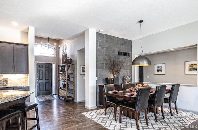 dining room with dark wood-style floors, baseboards, visible vents, and a chandelier