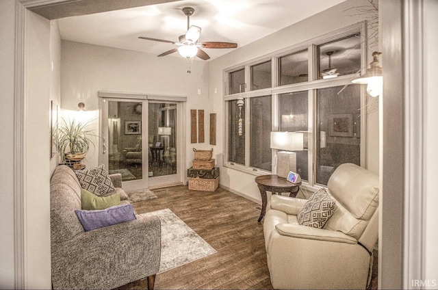 living area featuring dark wood-style flooring, ceiling fan, and baseboards