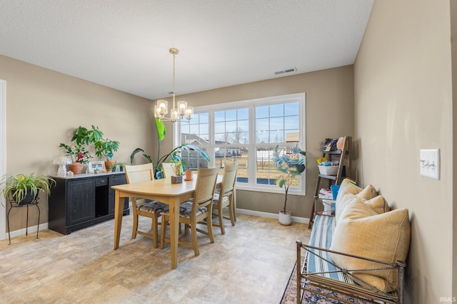 dining space with baseboards, visible vents, a chandelier, and a textured ceiling