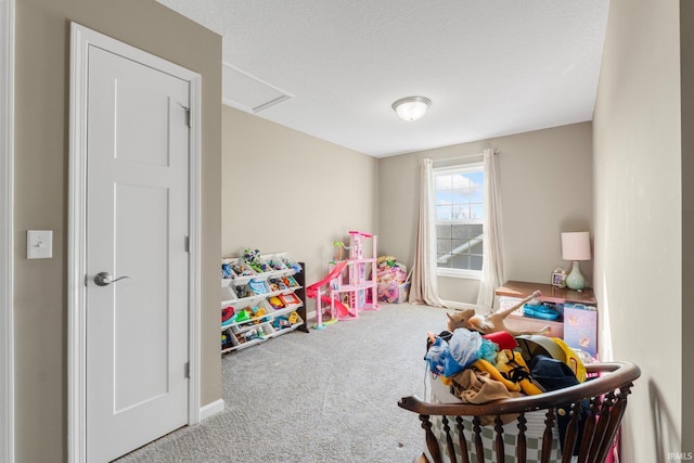 playroom featuring a textured ceiling and carpet flooring