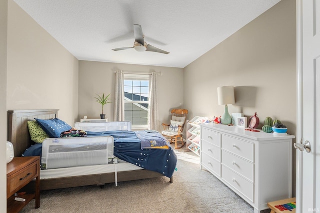 bedroom featuring a textured ceiling, ceiling fan, and light colored carpet