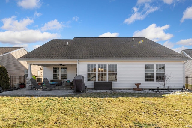 back of house featuring a patio, a lawn, fence, and roof with shingles