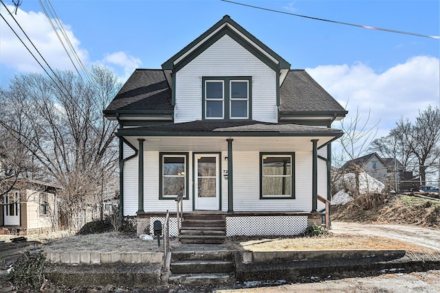 bungalow with a porch and a shingled roof