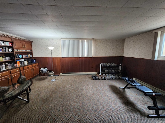 interior space featuring a baseboard radiator, wooden walls, carpet flooring, wainscoting, and wallpapered walls