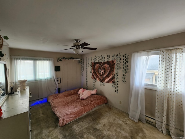 bedroom featuring carpet, multiple windows, a baseboard heating unit, and a ceiling fan