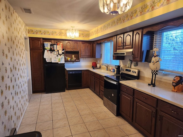 kitchen featuring black appliances, an inviting chandelier, light countertops, and wallpapered walls