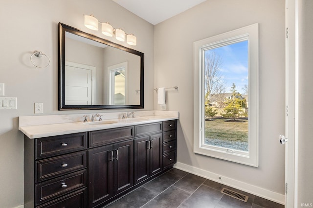 full bath with double vanity, baseboards, visible vents, tile patterned floors, and a sink