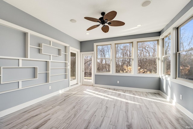 unfurnished sunroom with a ceiling fan