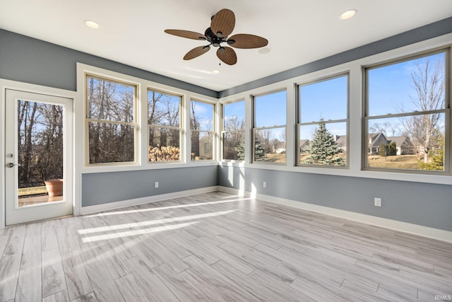 unfurnished sunroom featuring ceiling fan