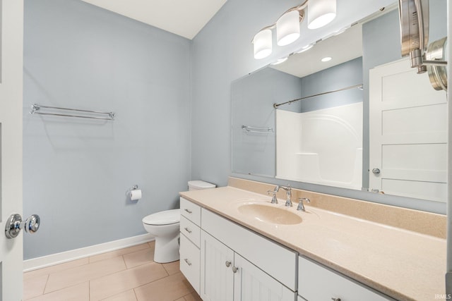 bathroom with tile patterned floors, toilet, vanity, baseboards, and walk in shower