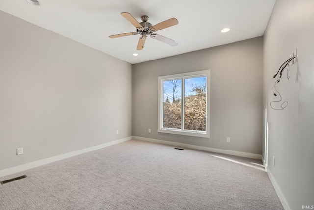 spare room featuring carpet floors, baseboards, visible vents, and a ceiling fan