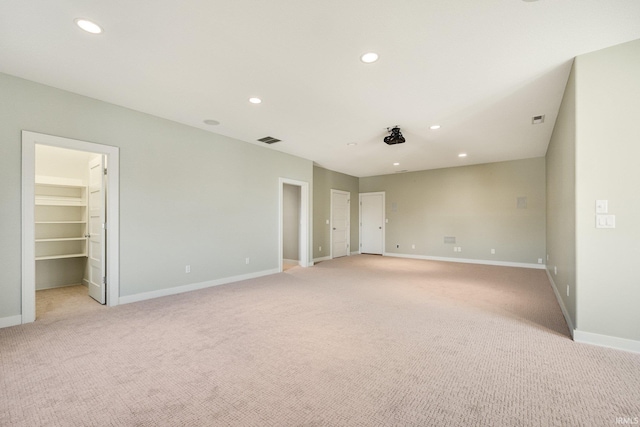 unfurnished room with recessed lighting, light colored carpet, visible vents, and baseboards