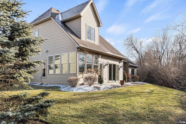 view of home's exterior featuring a lawn and roof with shingles