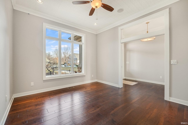 empty room with baseboards, dark wood-type flooring, and crown molding