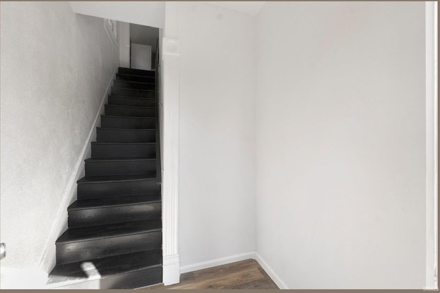 staircase with baseboards and wood finished floors