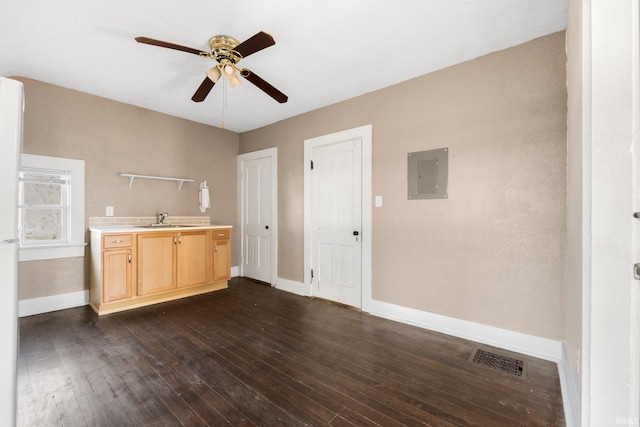 kitchen featuring visible vents, light countertops, electric panel, dark wood-style floors, and light brown cabinetry