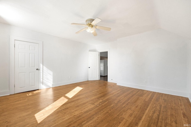 unfurnished room featuring lofted ceiling, ceiling fan, baseboards, and wood finished floors