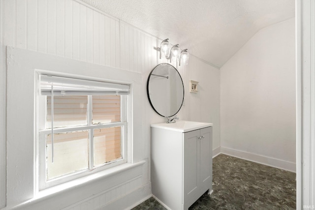 bathroom featuring lofted ceiling, baseboards, a textured ceiling, and vanity