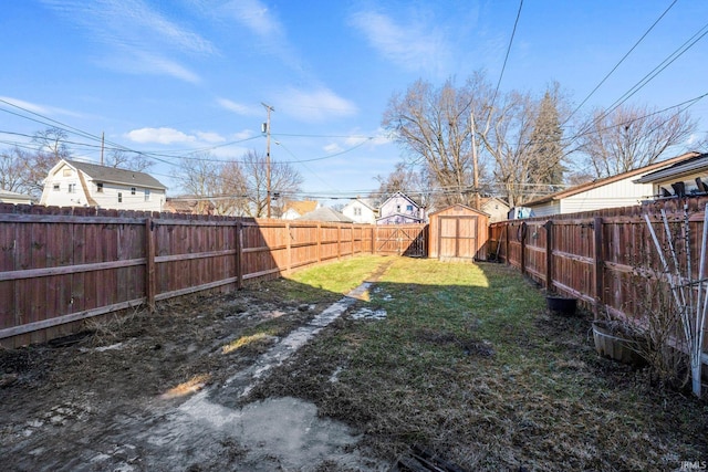 view of yard with a storage shed, an outdoor structure, and a fenced backyard