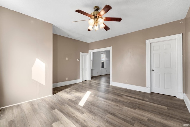 unfurnished bedroom with a ceiling fan, baseboards, and wood finished floors