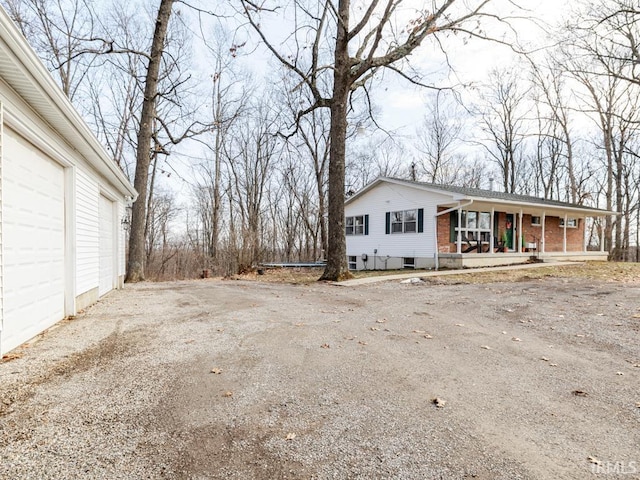 exterior space featuring a garage, covered porch, and brick siding