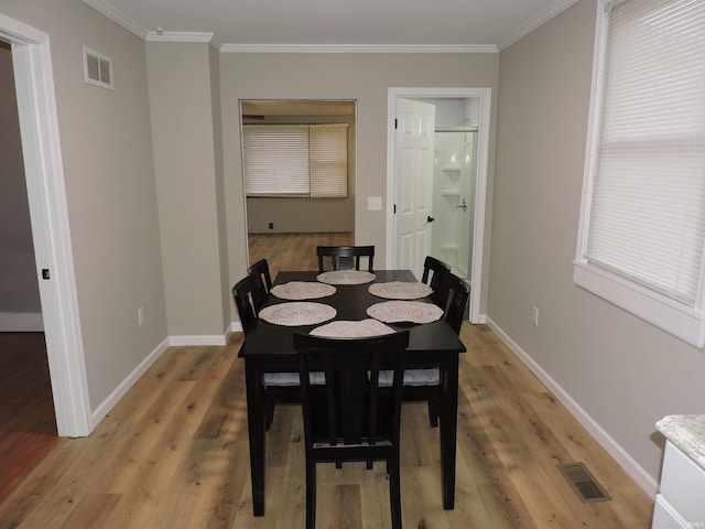 dining area with visible vents, crown molding, and wood finished floors