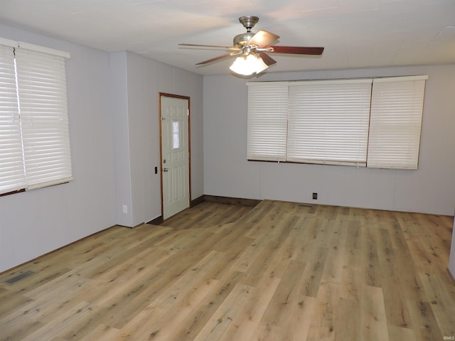 spare room featuring light wood finished floors, visible vents, and a ceiling fan