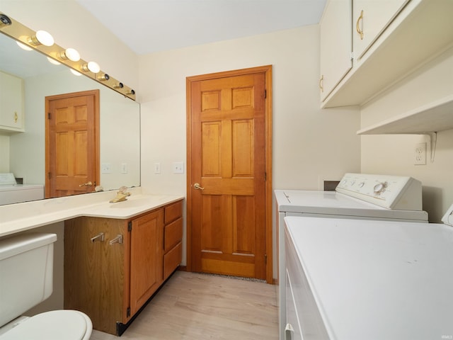 interior space featuring toilet, independent washer and dryer, wood finished floors, and vanity