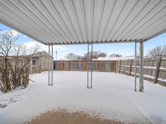 snowy yard with a fenced backyard