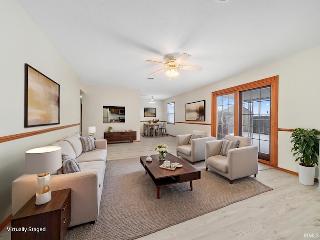 living room with light wood-style floors and a ceiling fan