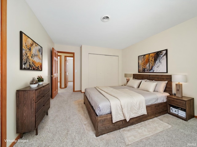 bedroom featuring light colored carpet, a closet, visible vents, and baseboards