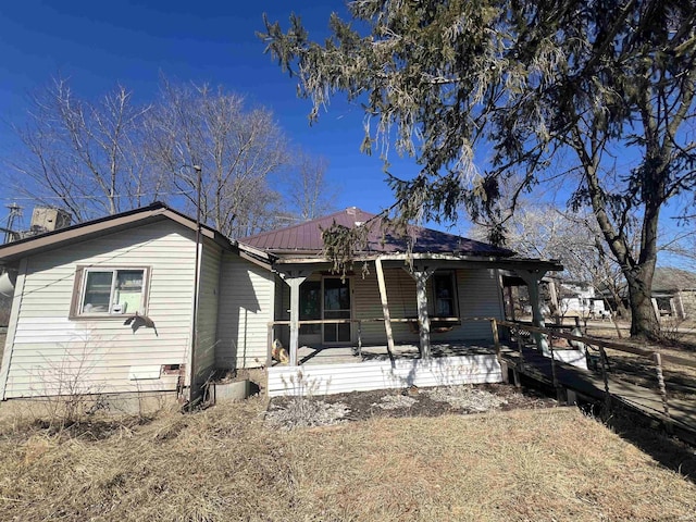 back of house featuring metal roof