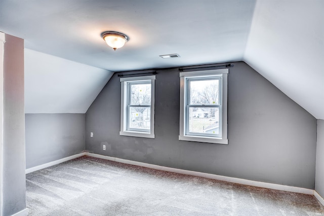 bonus room featuring lofted ceiling, visible vents, light carpet, and baseboards