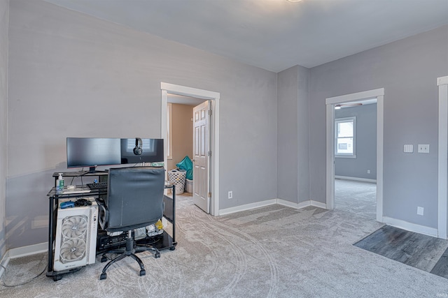 home office featuring light carpet and baseboards