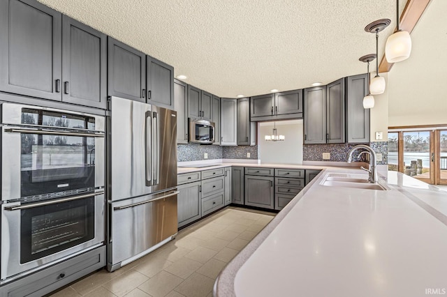 kitchen with decorative backsplash, stainless steel appliances, a sink, and light countertops