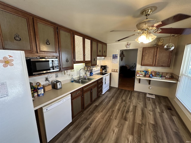 kitchen featuring dark wood-style floors, light countertops, a sink, white appliances, and under cabinet range hood