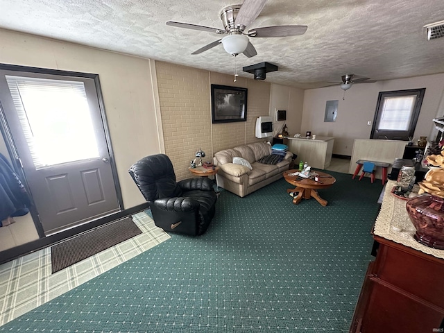 carpeted living room featuring ceiling fan, visible vents, and a textured ceiling