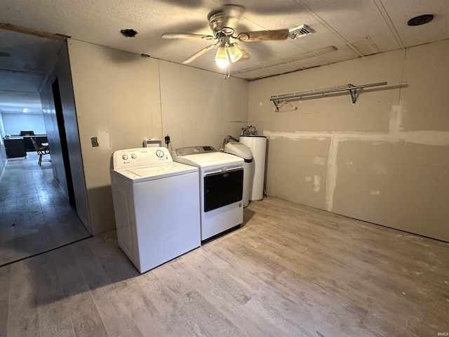 washroom with visible vents, light wood-style floors, a ceiling fan, washer and dryer, and laundry area