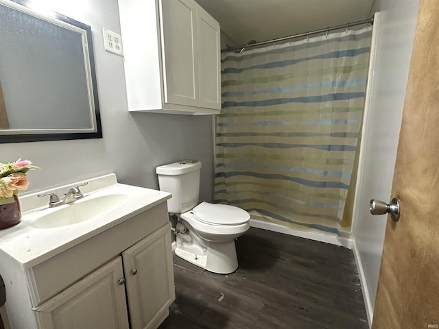 bathroom featuring toilet, a shower with shower curtain, wood finished floors, and vanity