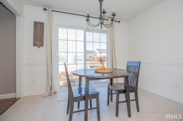 dining space featuring baseboards, a chandelier, and light tile patterned flooring