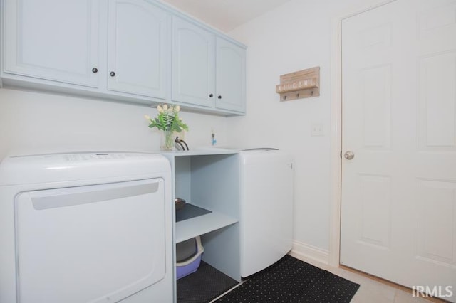 washroom featuring washer / clothes dryer, cabinet space, and light tile patterned floors