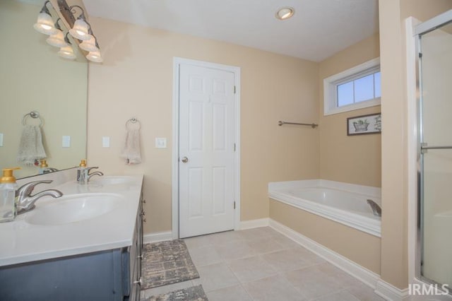 full bathroom with a stall shower, tile patterned flooring, a garden tub, and a sink