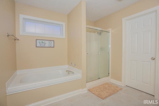 full bathroom featuring tile patterned flooring, a garden tub, and a shower stall