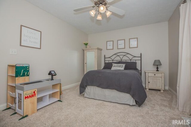 bedroom featuring light carpet, baseboards, and a ceiling fan