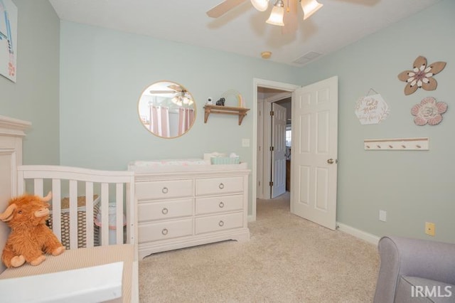 bedroom with ceiling fan, visible vents, baseboards, and light colored carpet